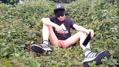 Jon Arteen, a gay Asian twink, is dressed in an Adidas t-shirt, hot pants, white socks, and Duramo sneakers. He jerks off his shaved cock and ejaculates thick cum outdoors.